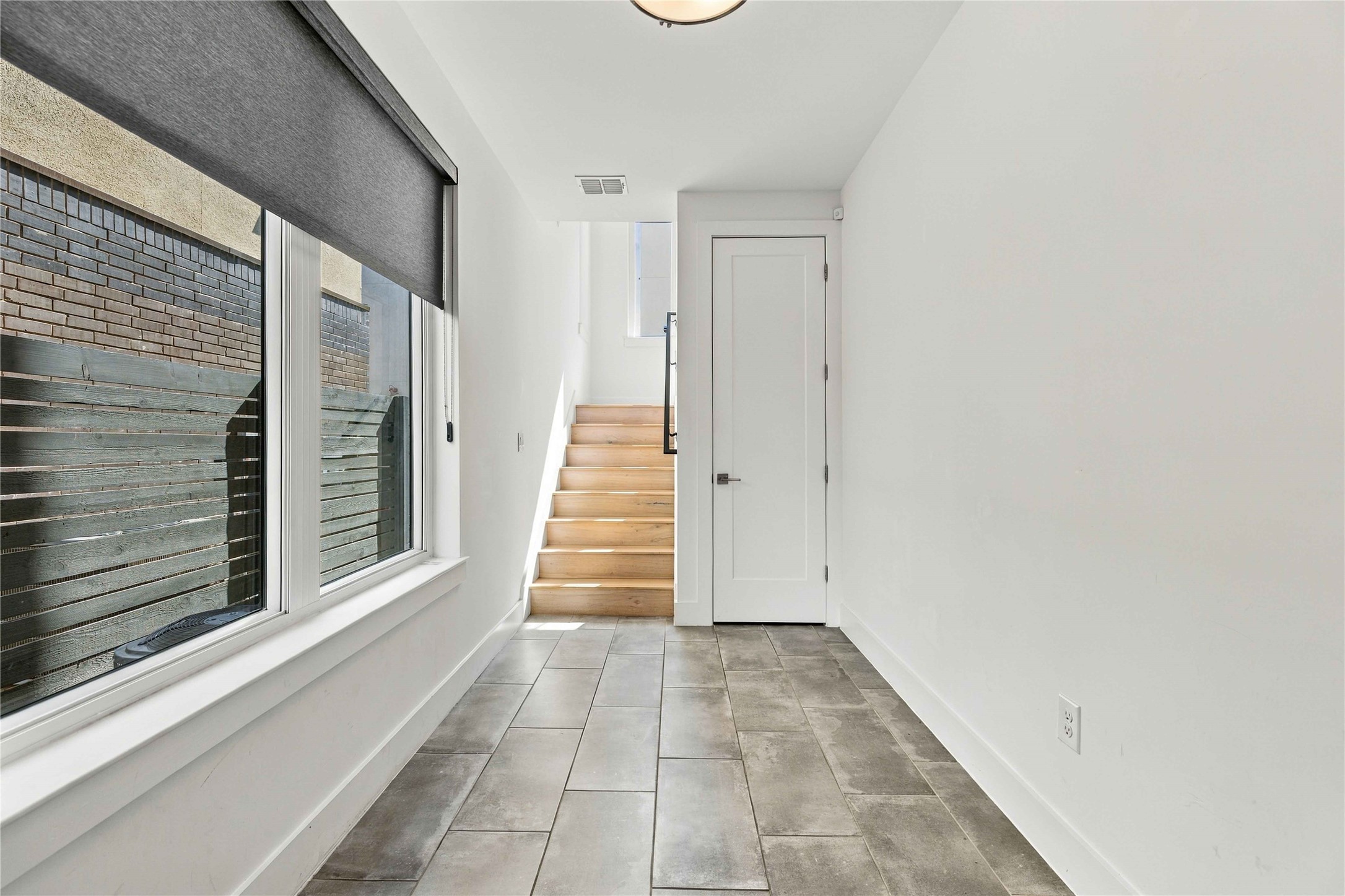 5006 Pecan Springs Road, Unit 7 Austin, TX 78723 - Photo 6 of 38 Clean lines and tiled flooring define this bright entryway leading directly to wood stairs.