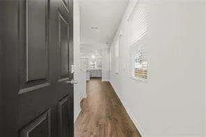 a view of a hallway with wooden floor and staircase