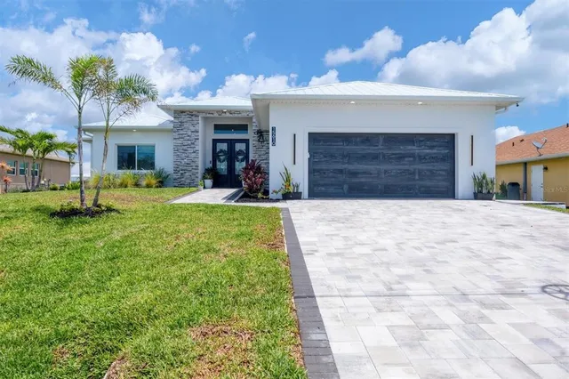 a view of an house with backyard and a tree