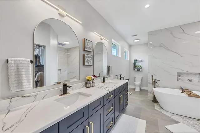 a bathroom with a granite countertop sink a toilet and a mirror