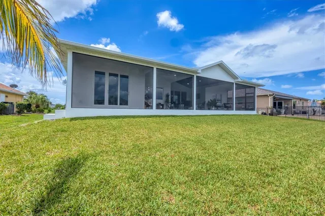 a view of a lake with a yard and large trees