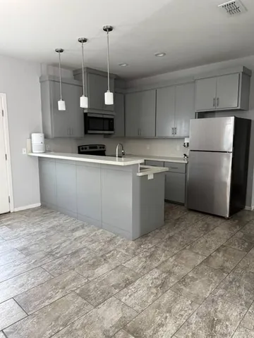 a kitchen with kitchen island a counter top space appliances and cabinets