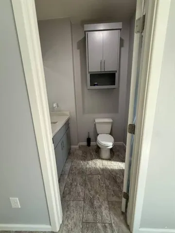 a bathroom with a toilet a sink and mirror