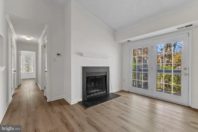 wooden floor fireplace and windows in an empty room