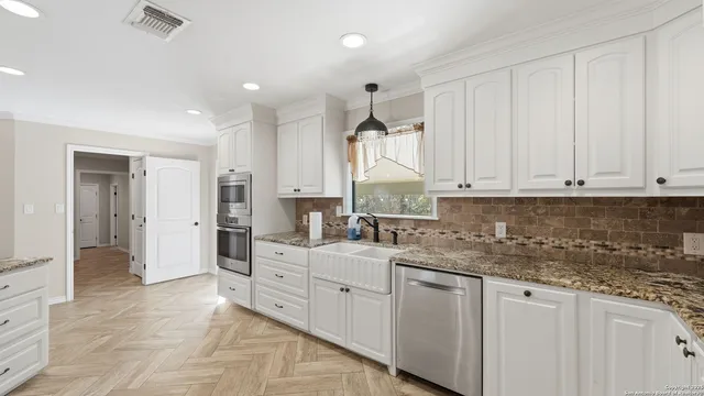 a kitchen with stainless steel appliances granite countertop a sink and cabinets