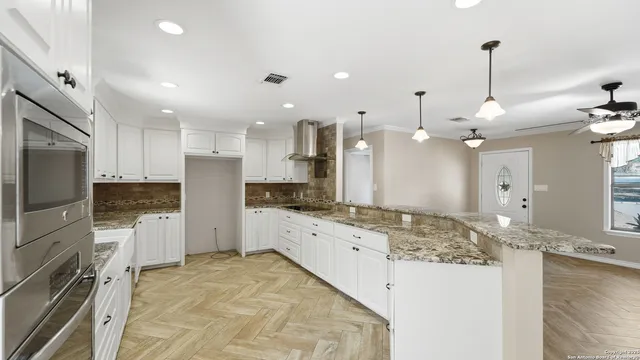a large kitchen with stainless steel appliances kitchen island granite countertop a large counter top and stove top oven