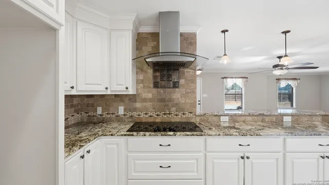 a kitchen with granite countertop white cabinets and a sink