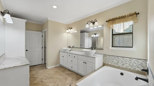 a bathroom with a double vanity sink mirror and bathtub