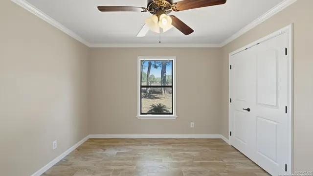 an empty room with windows and fan