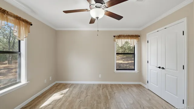 a view of an empty room with a window and wooden floor