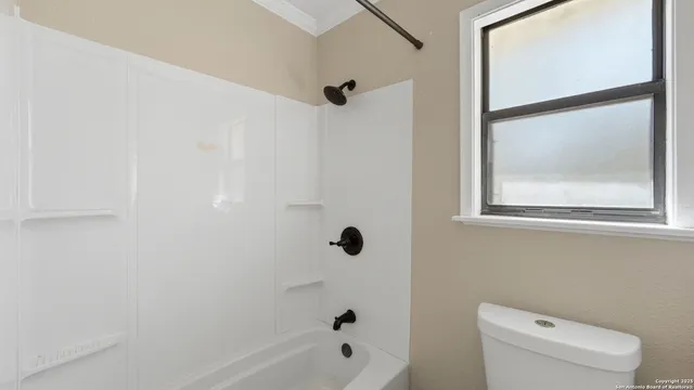 a bathroom with a shower a toilet and a mirror