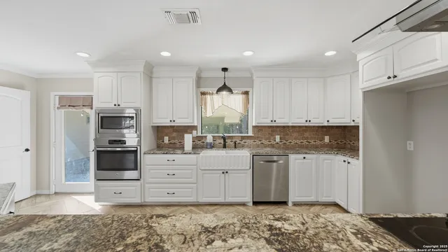 a kitchen with stainless steel appliances granite countertop a stove a sink and a refrigerator