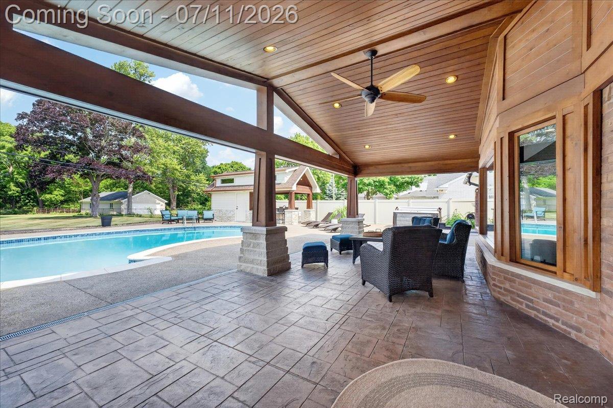 23750 East River Road Grosse Ile, MI 48138 - Photo 37 of 54 Expansive covered patio featuring stamped concrete flooring, a wood-paneled ceiling with recessed lighting and a ceiling fan, and substantial exposed wood beams