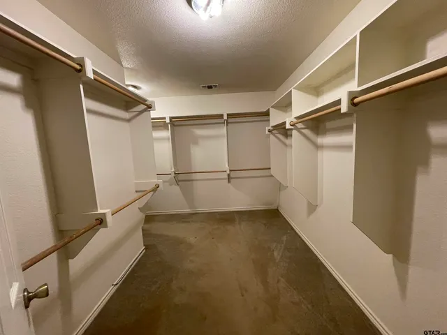 an empty room with a chandelier fan