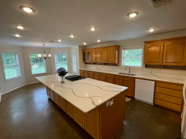 a large kitchen with kitchen island a sink a stove a dining table and chairs