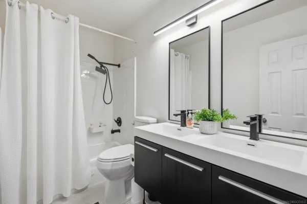 a bathroom with a double vanity sink toilet and shower