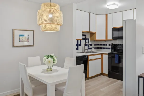 a kitchen with stainless steel appliances a white stove top oven a sink a chimney and a refrigerator