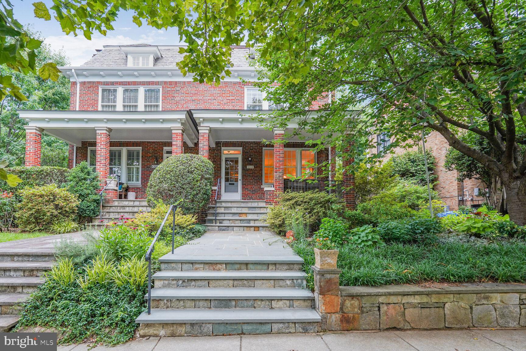 Charming brick home with lush greenery.