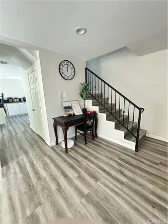 a view of a hallway with wooden floor and a chandelier
