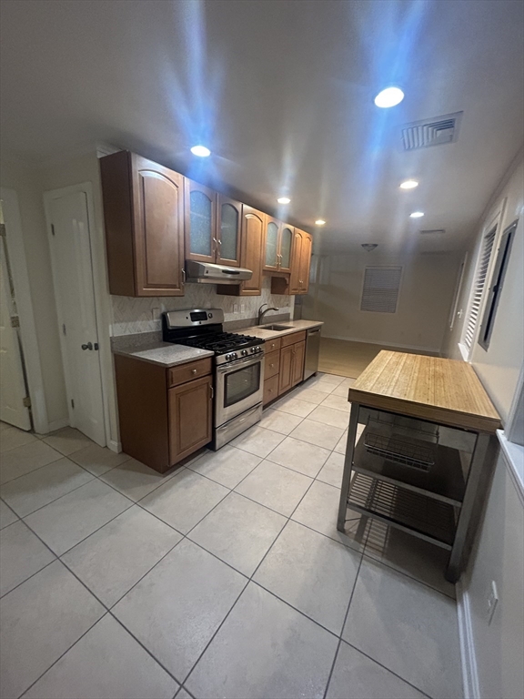 a kitchen with stainless steel appliances kitchen island granite countertop a stove a sink and a microwave