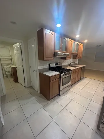 a kitchen with stainless steel appliances granite countertop a stove a sink and a refrigerator