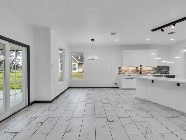 an empty room with white walls and windows