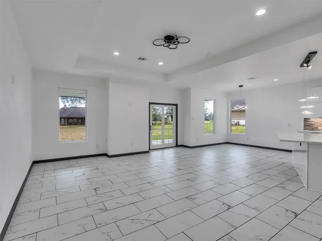 a spacious bathroom with a sink a toilet a mirror and shower