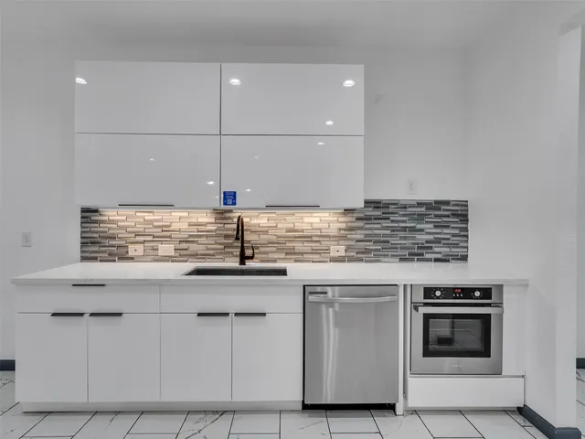 a kitchen with granite countertop a sink and cabinets