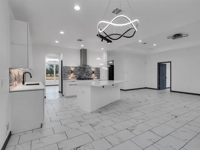 a kitchen with stainless steel appliances kitchen island granite countertop a sink and cabinets