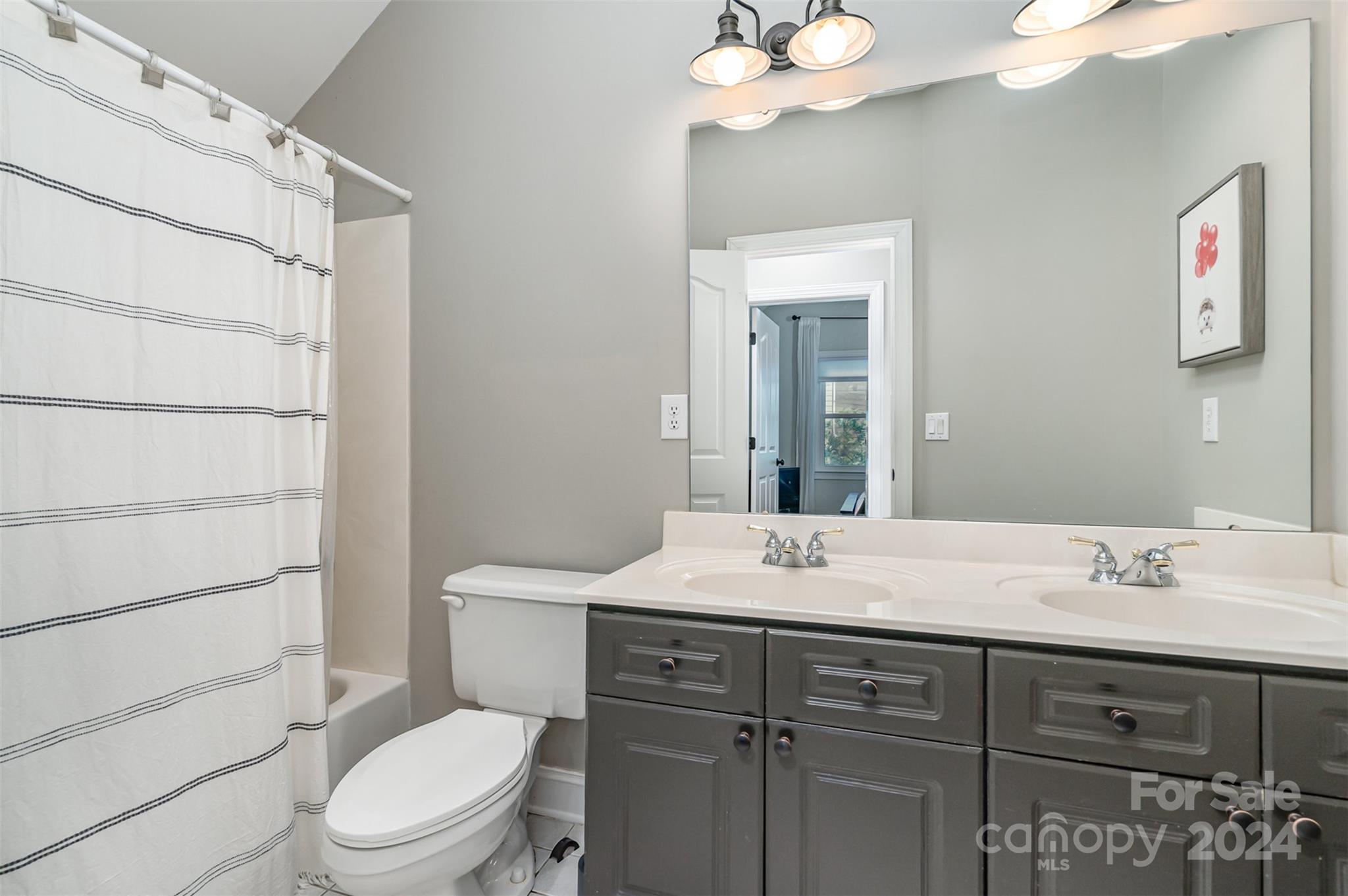 3410 Rhett Butler Place Charlotte, NC 28270 - Photo 24 of 31 a bathroom with a sink vanity granite toilet and a mirror