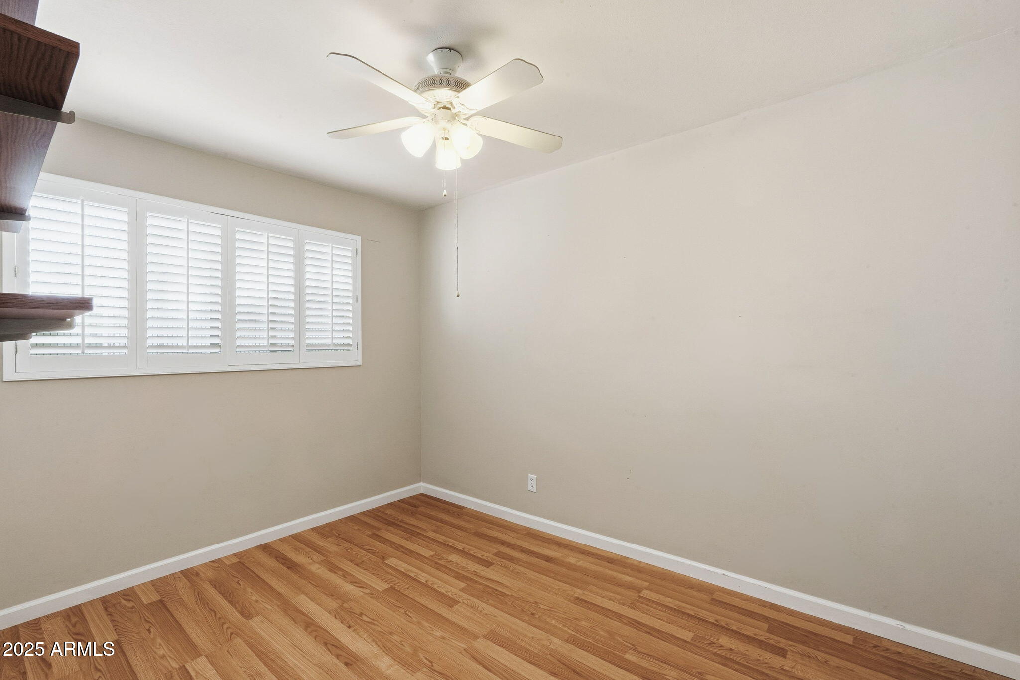 1208 North Palm Ln Circle Coolidge, AZ 85128 - Photo 20 of 33 an empty room with wooden floor and windows