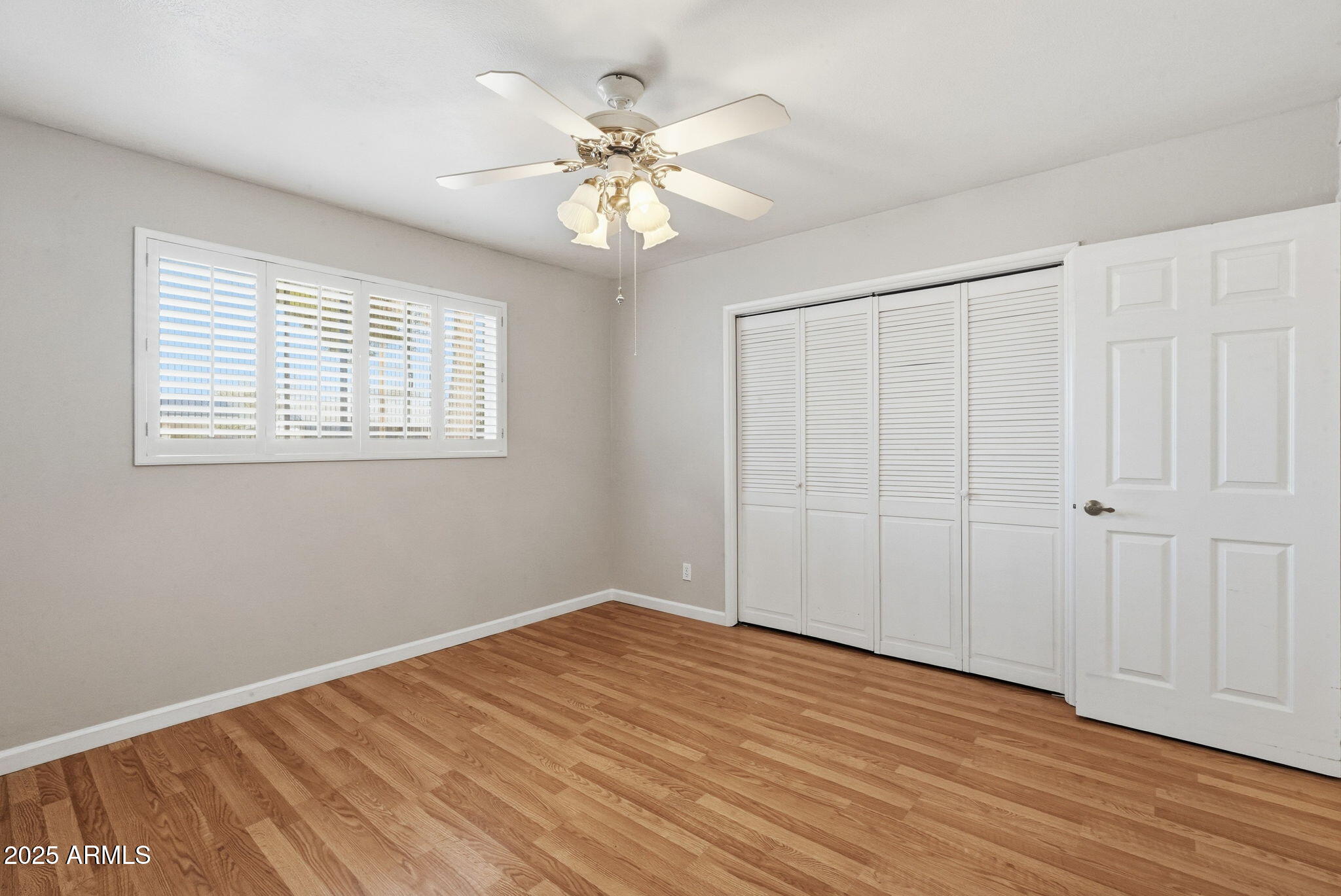 1208 North Palm Ln Circle Coolidge, AZ 85128 - Photo 22 of 33 a view of an empty room with wooden floor and a window