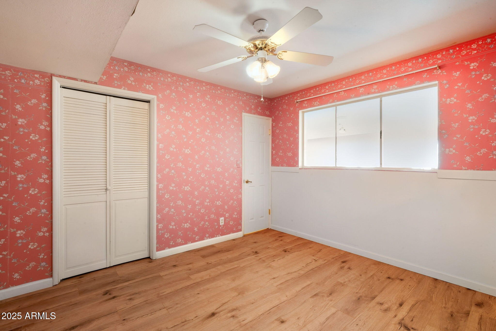 1208 North Palm Ln Circle Coolidge, AZ 85128 - Photo 24 of 33 an empty room with wooden floor and a ceiling fan