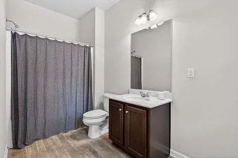 a bathroom with a granite countertop sink toilet and a mirror