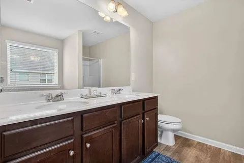 a bathroom with a granite countertop sink a toilet and a mirror