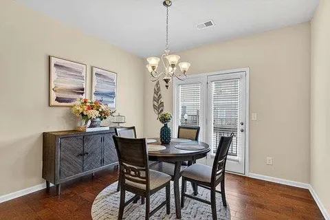 a dining room with furniture a chandelier and wooden floor