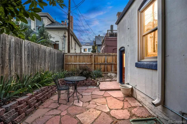 a backyard of a house with table and chairs