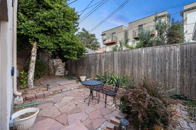 a backyard of a house with table and chairs