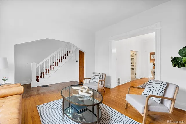a living room with furniture and wooden floor