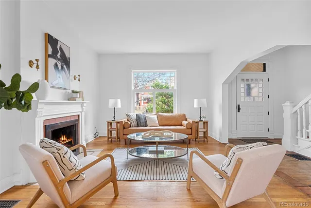 a living room with furniture a fireplace and a table