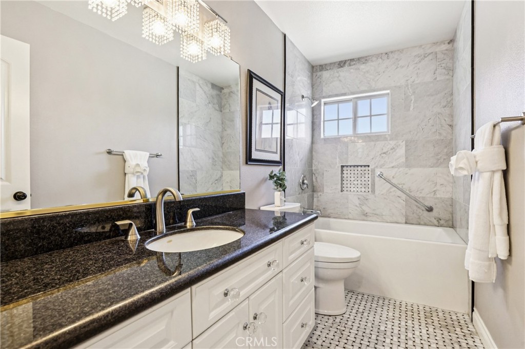 13541 Dean Street Tustin, CA 92780 - Photo 14 of 30 a bathroom with a granite countertop sink toilet a mirror a vanity and shower