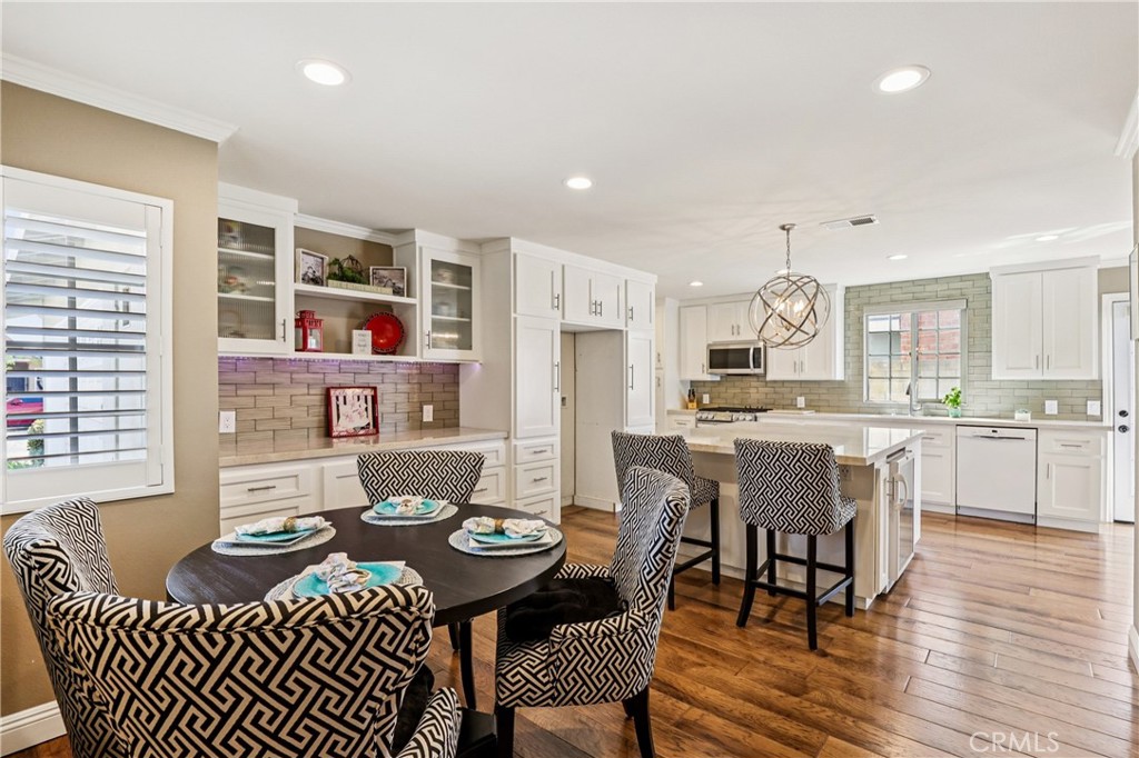 13541 Dean Street Tustin, CA 92780 - Photo 5 of 30 a dining room with kitchen island stainless steel appliances a table and chairs