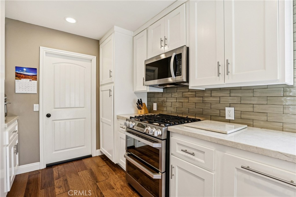 13541 Dean Street Tustin, CA 92780 - Photo 8 of 30 a kitchen with white cabinets and appliances
