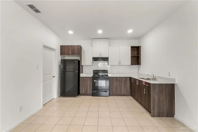 a kitchen with stainless steel appliances granite countertop a refrigerator and a sink