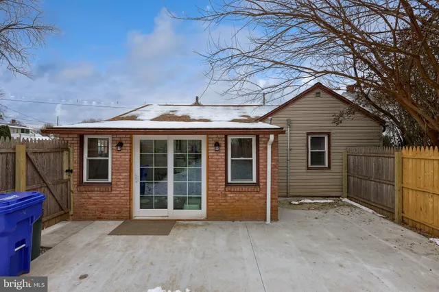 a view of a house with a large window and wooden fence