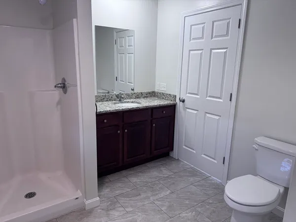 a bathroom with a sink a toilet and shower