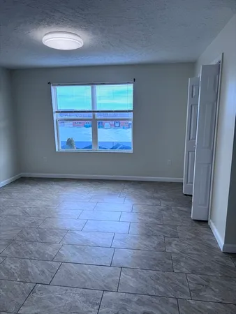 an empty room with a fireplace and windows