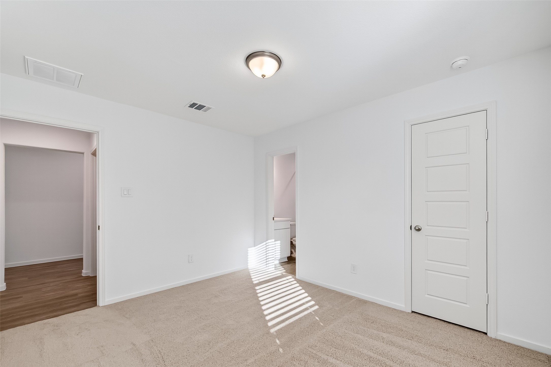 2115 Spring Hollow Drive Baytown, TX 77521 - Photo 21 of 36 an empty room with wooden floor and white walls