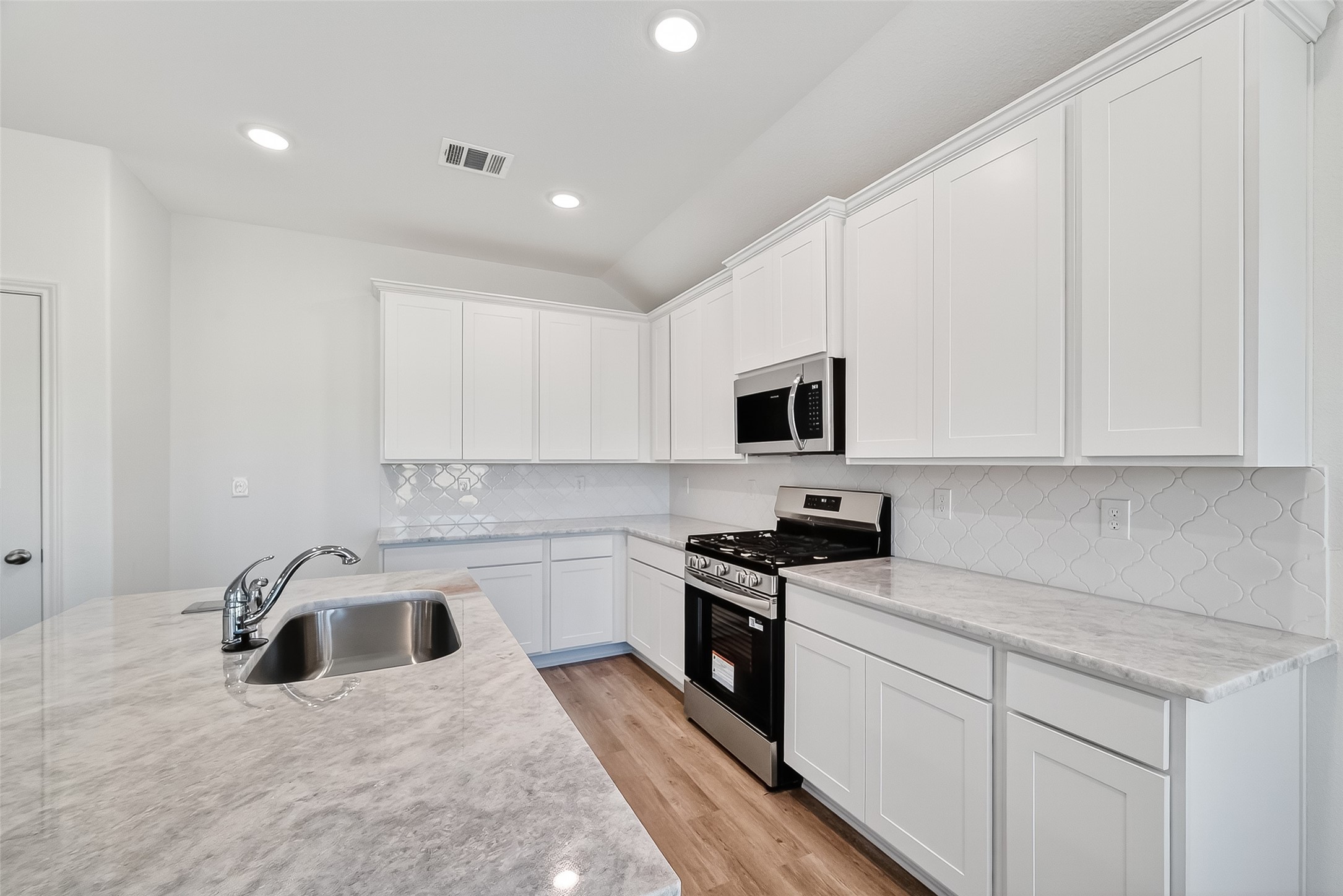 2115 Spring Hollow Drive Baytown, TX 77521 - Photo 9 of 36 a kitchen with granite countertop white cabinets and white appliances