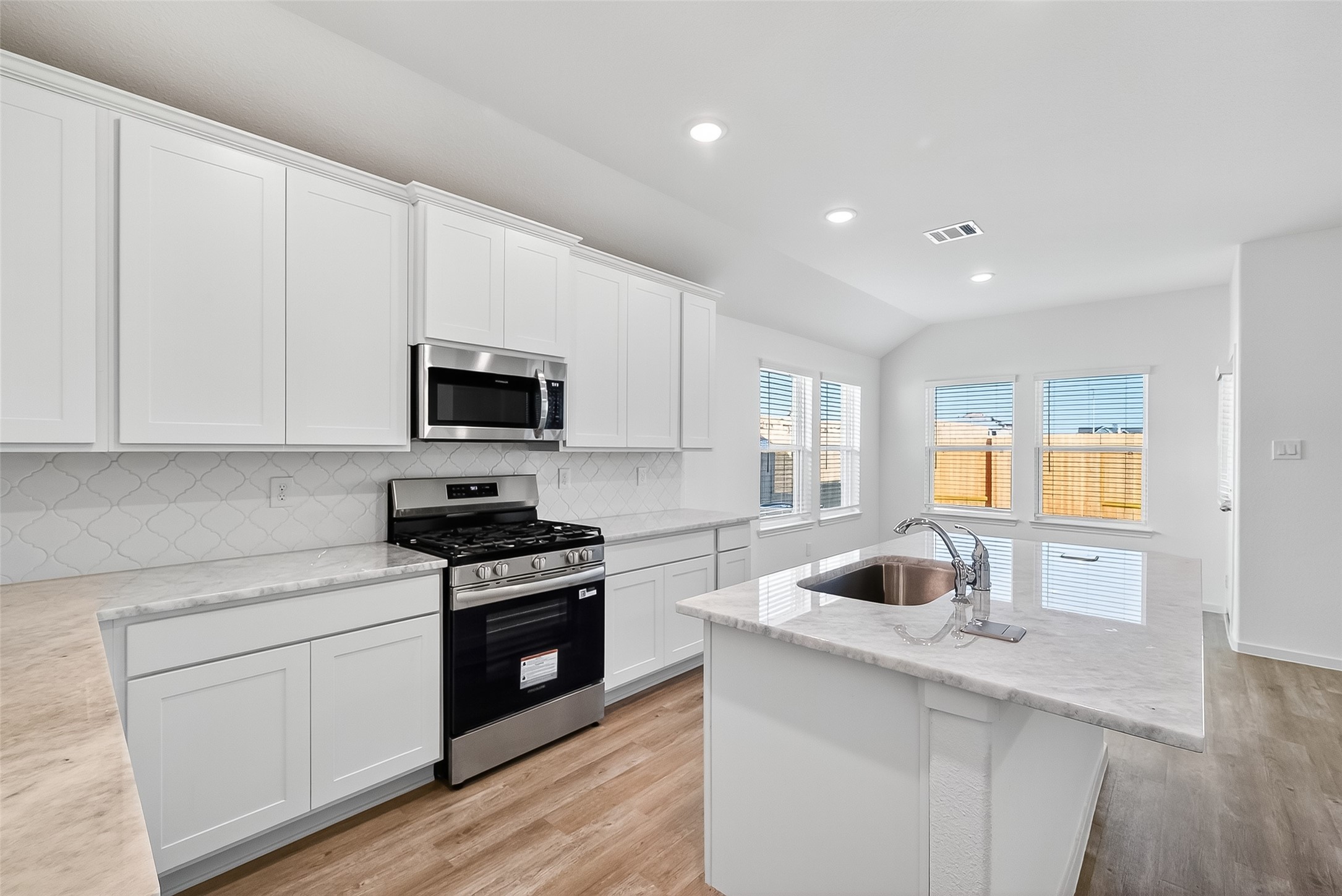 2115 Spring Hollow Drive Baytown, TX 77521 - Photo 10 of 36 a kitchen with granite countertop white cabinets and black stainless steel appliances